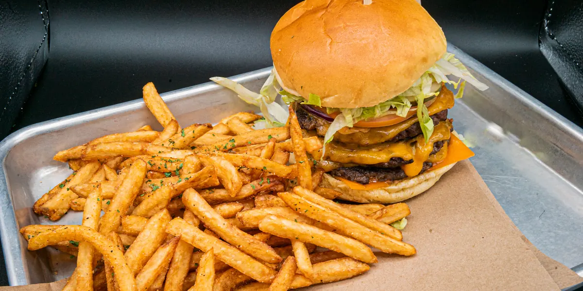 A stacked Perfect SZN triple burger with seasoned fries